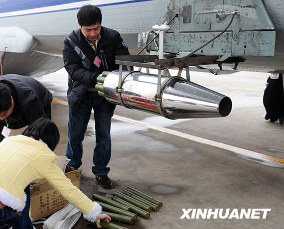 資料圖：2月8日，在河南省鄭州市新鄭機(jī)場，工作人員往飛機(jī)上裝掛人工增雨用的碘化銀催化劑。