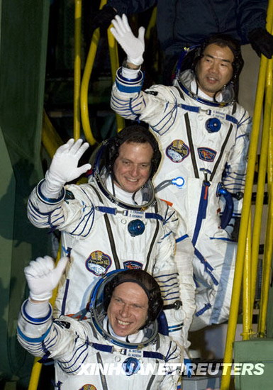 21日，在哈薩克斯坦境內(nèi)的拜科努爾航天發(fā)射中心，國際空間站第22長期考察組成員俄羅斯宇航員奧列格·科托夫、美國宇航員蒂莫西·克里默和日本宇航員野口聰一（從下至上）在進入飛船前向人們揮手。