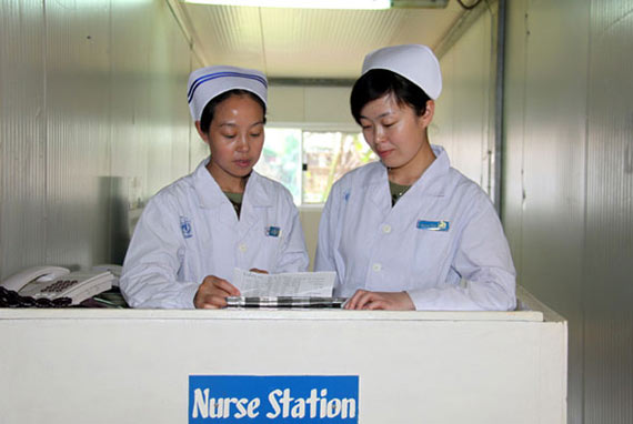 圖為護士長高翠玲(左)和護士孫艷傳授護理技巧。